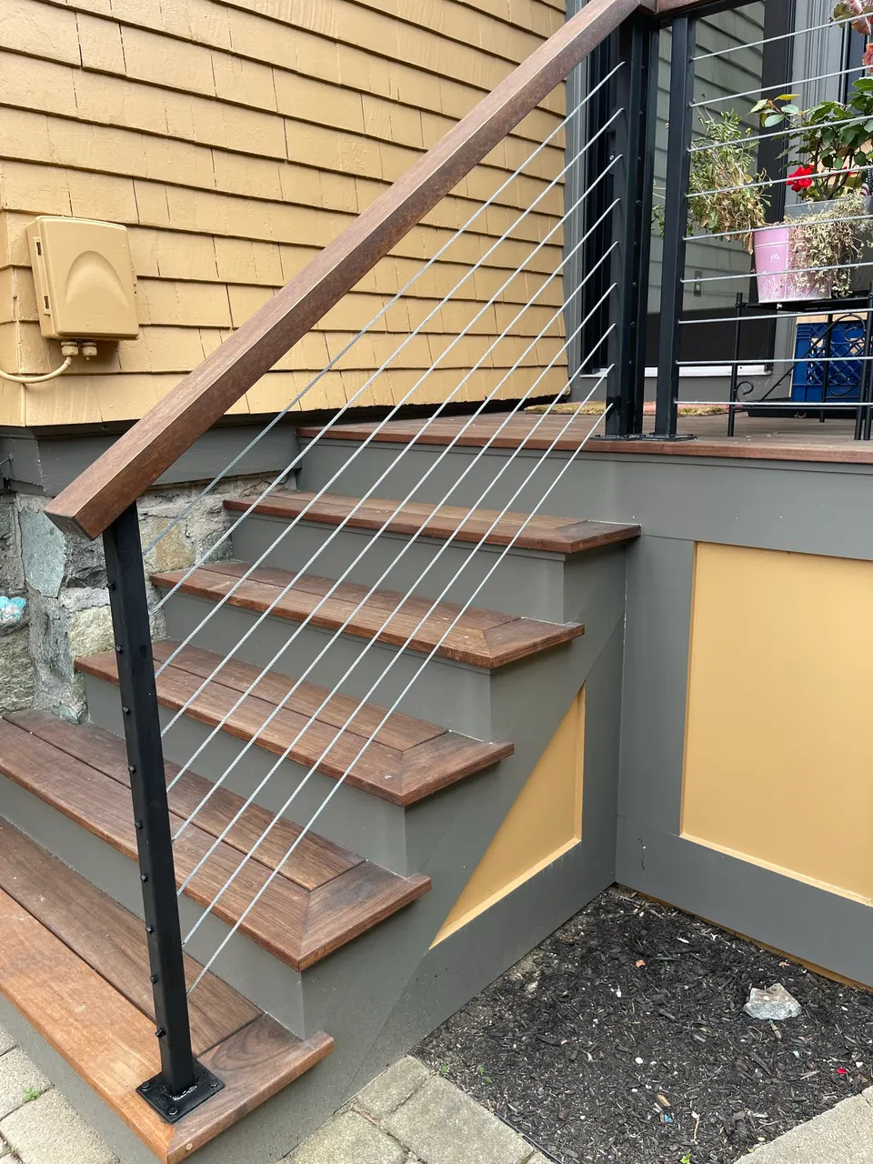 Exterior stair with horizontal cable railing and a wood top rail