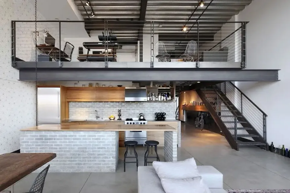 Open interior mezzanine with dark metal railings and a coordinating staircase