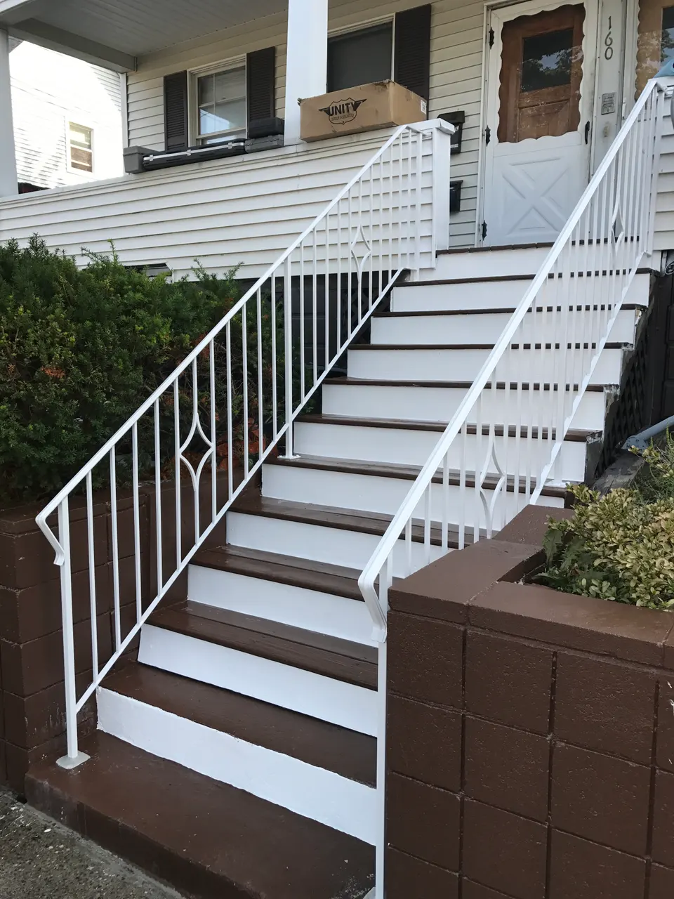 White painted metal railings with a diamond detail along exterior steps